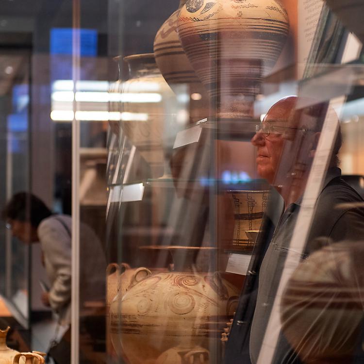A visitor looking at pieces from the Bronze Age made in Crete.