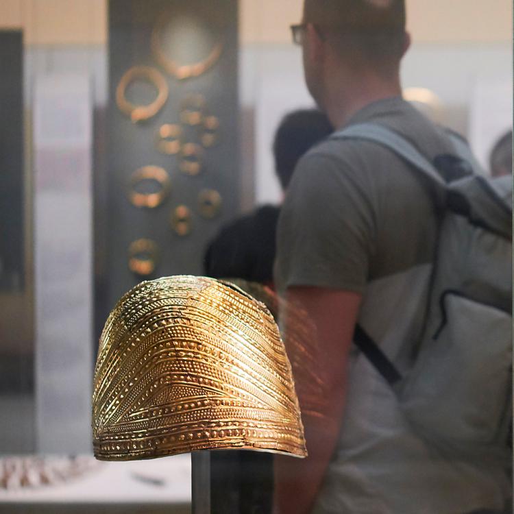 The Gold cape in Room 51 was worn for ceremonies. The neck is not very wide and it's curving downwards shows it would have restricted upper arm movement