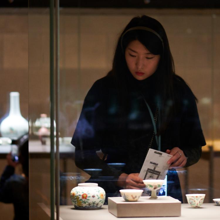 A visitor examining the Korean ceramics in Room 95
