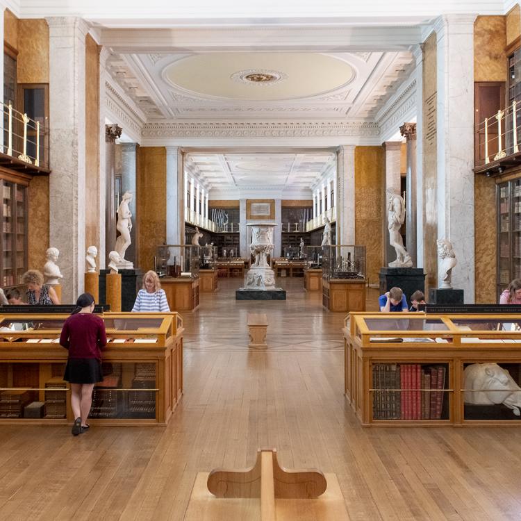 Small groups of children and adults looking in display cases in the Enlightenment gallery.