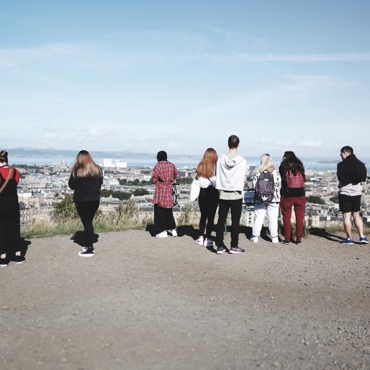 Group of young people looking out to Edinburgh city and sea.