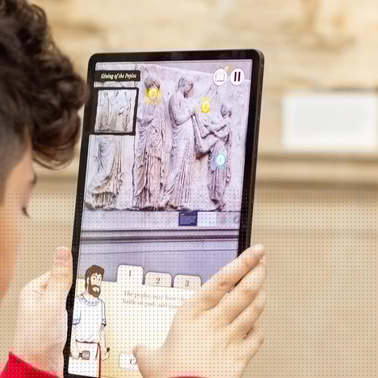 Student pointing a Samsung tablet at a marble sculpture and reading information about the sculpture on the tablet. 