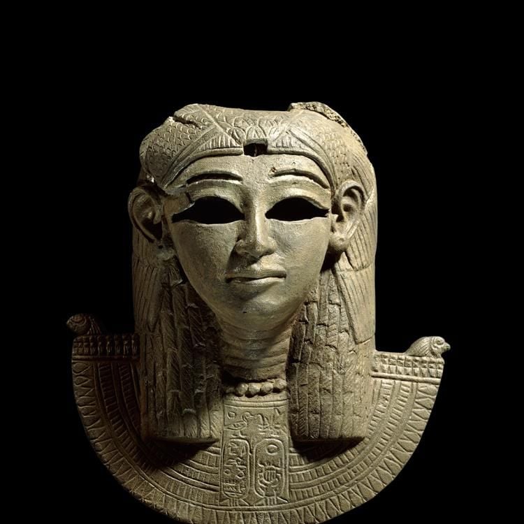 A bronze ceremonial mask of a goddess wearing an ornate headdress and collar, from the prow of a ship.