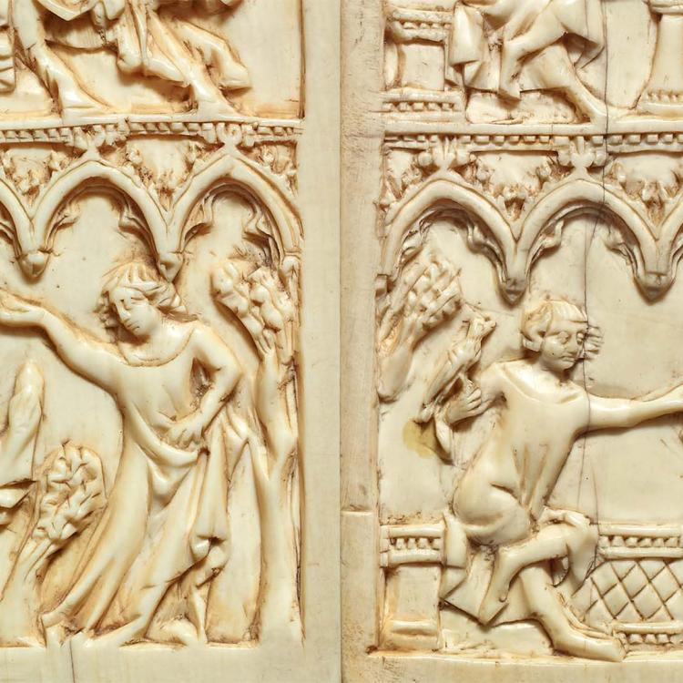 A writing tablet made of bone or ivory depicting scenes of a pair of lovers. In the one on the left a woman places a flower crown on the head of the young man, and in the one on the right, a woman cradles an animal in her lap while the man carries a bird of prey