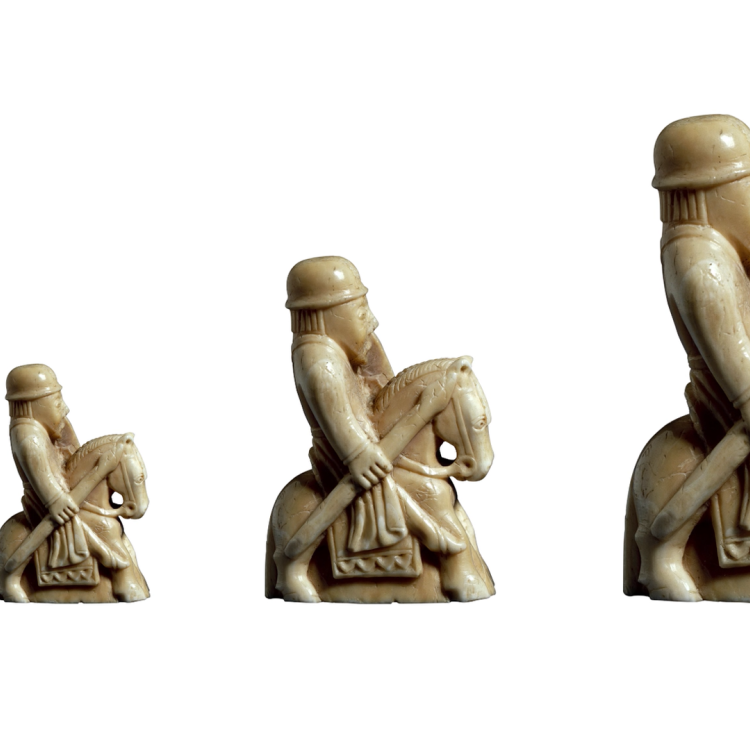 Four identical carvings of a figure on a horse arranged side-by-side, doubling in height each time from left to right.