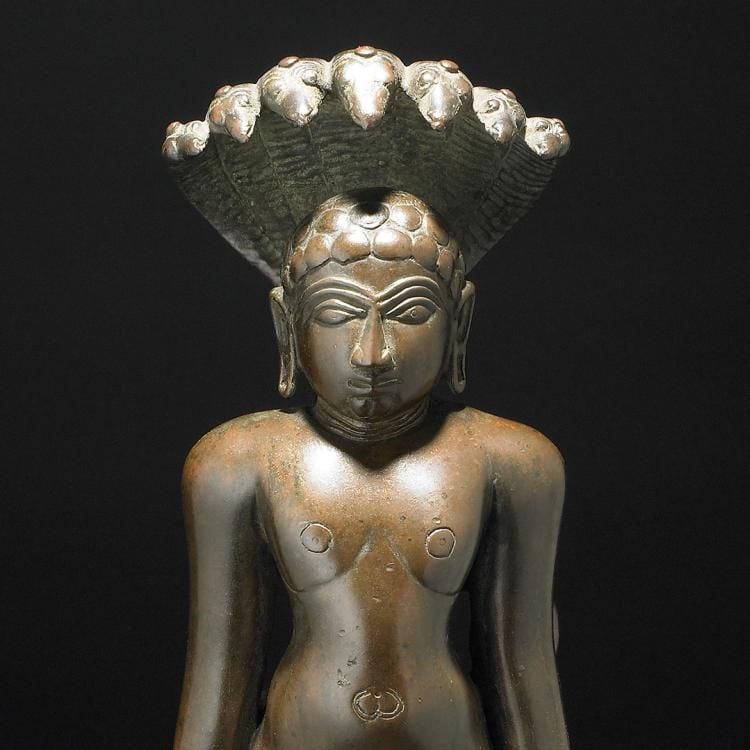 A bronze sculpture of a standing figure with seven snakes creating a canopy above their head.