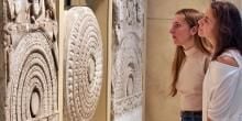 A visitor viewing a limestone Dome-slab early Buddhist sculptures from Amaravati depicting The Great Departure of Prince Siddhartha