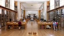Small groups of children and adults looking in display cases in the Enlightenment gallery.
