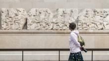 Visitor looking at reliefs in the Parthenon gallery.