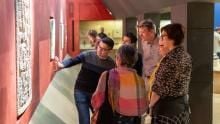 A tour group looking at lintel carvings in the Mexico gallery.