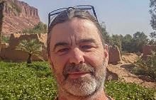 Headshot of Chris Breeden outside, mountainou