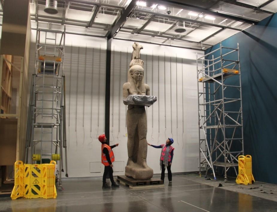 Two workmen moving statue