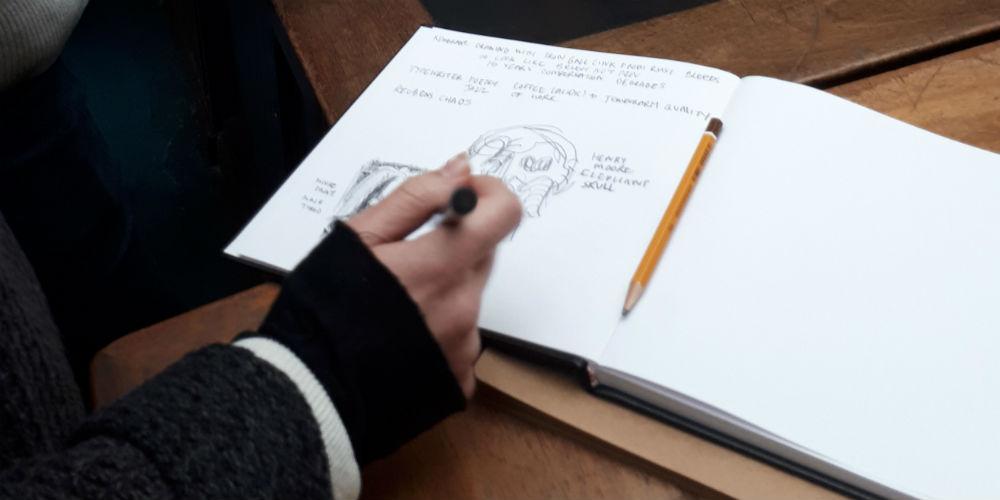 Student drawing in a sketch book