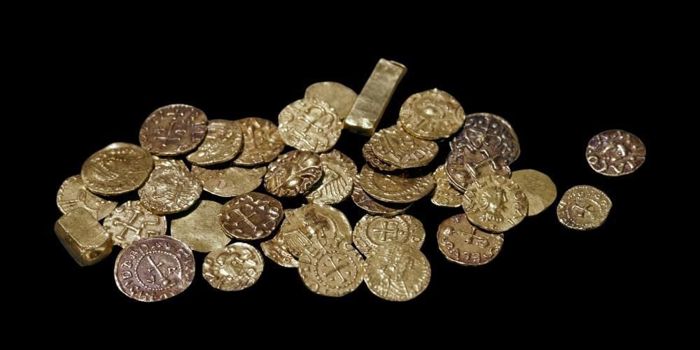 Over 20 gold coins laid out. 