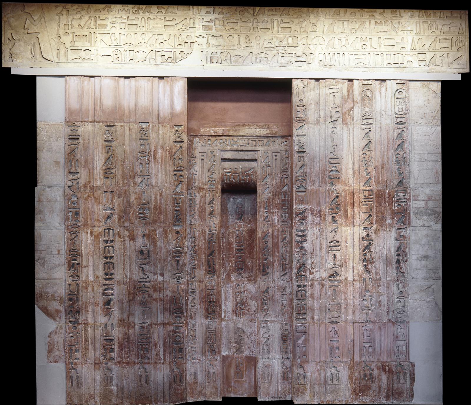 A large door with with hieroglyphics written upon it.