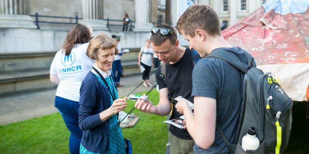 Volunteer helping visitors in front of Museum building