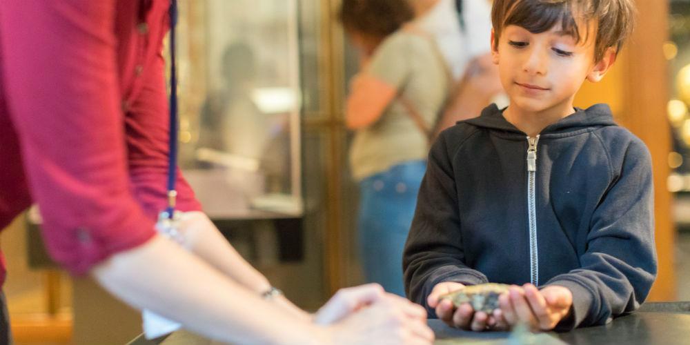 Boy holding object as Hands on desk