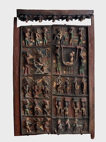 Large wooden door with 10 scenes featuring human figures. 