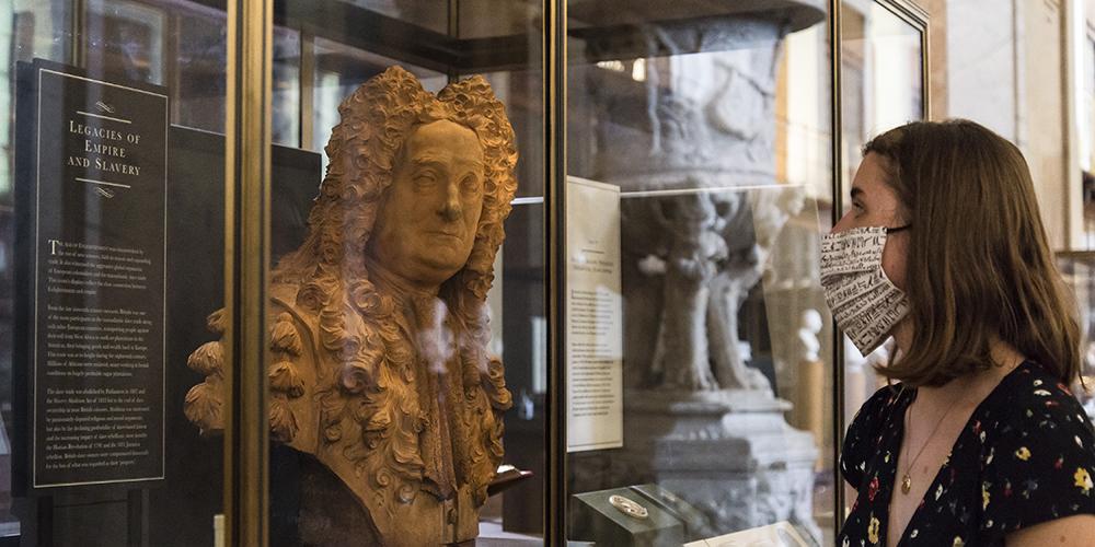 A visitor looking at the Hans Sloane bust.
