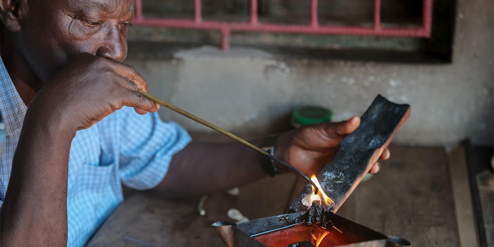 Man heating up a silver ornament.