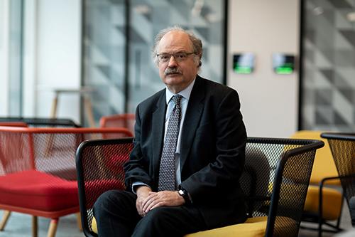 Mark Walport sitting down and looking into the camera.