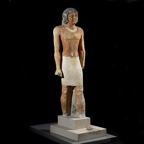 Painted limestone statue of Nenkheftka with damage to feet.