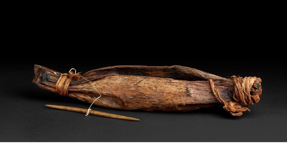 Container made of folded bark, tied at the ends with vegetable fibre. 