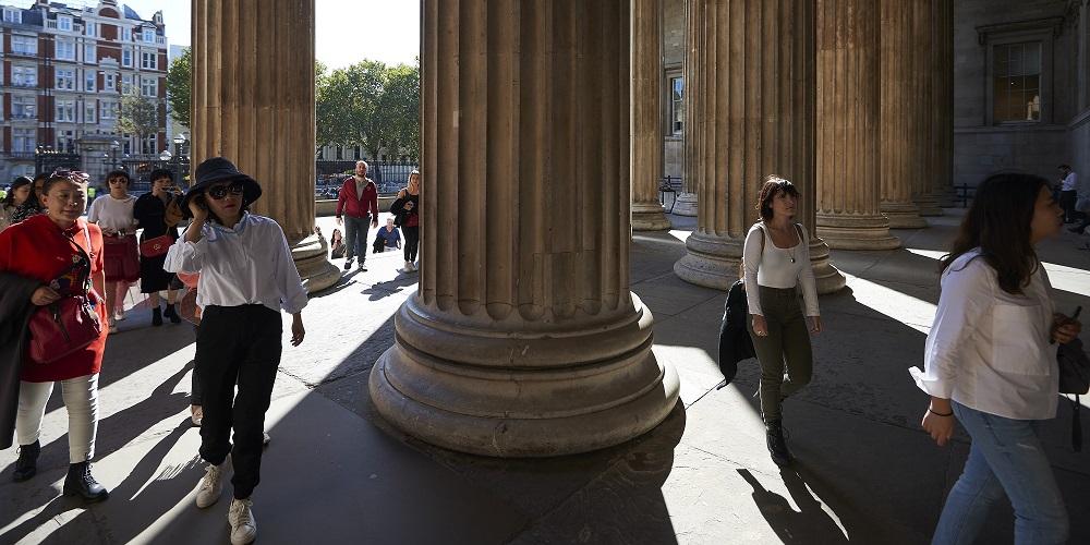 Visitors walk through the columns making up the colonnade entering the British Museum.