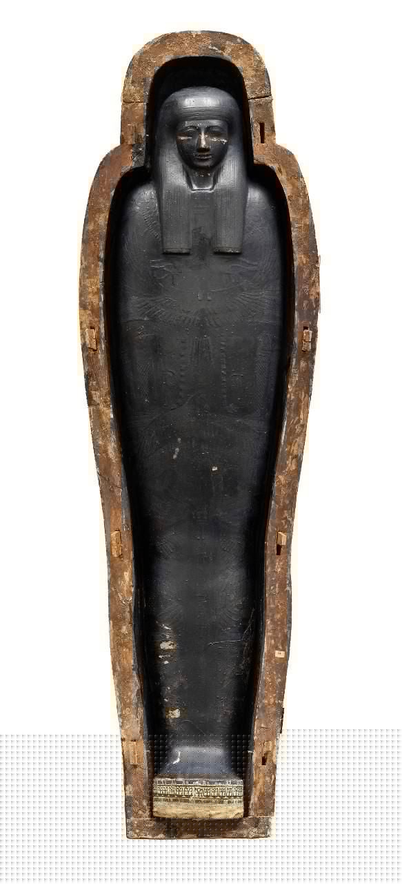 Overhead view of mummy encased in cartonnage in open wooden coffin