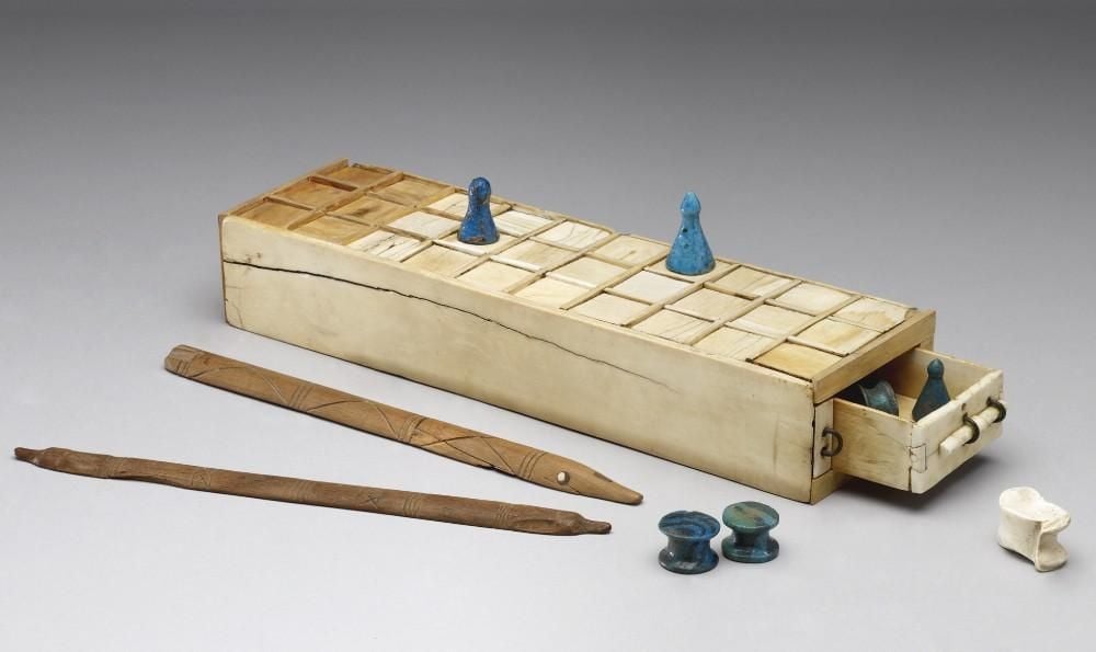 Rectangular games box formed, fitted with a drawer, games pieces on top, in open drawer and to the side