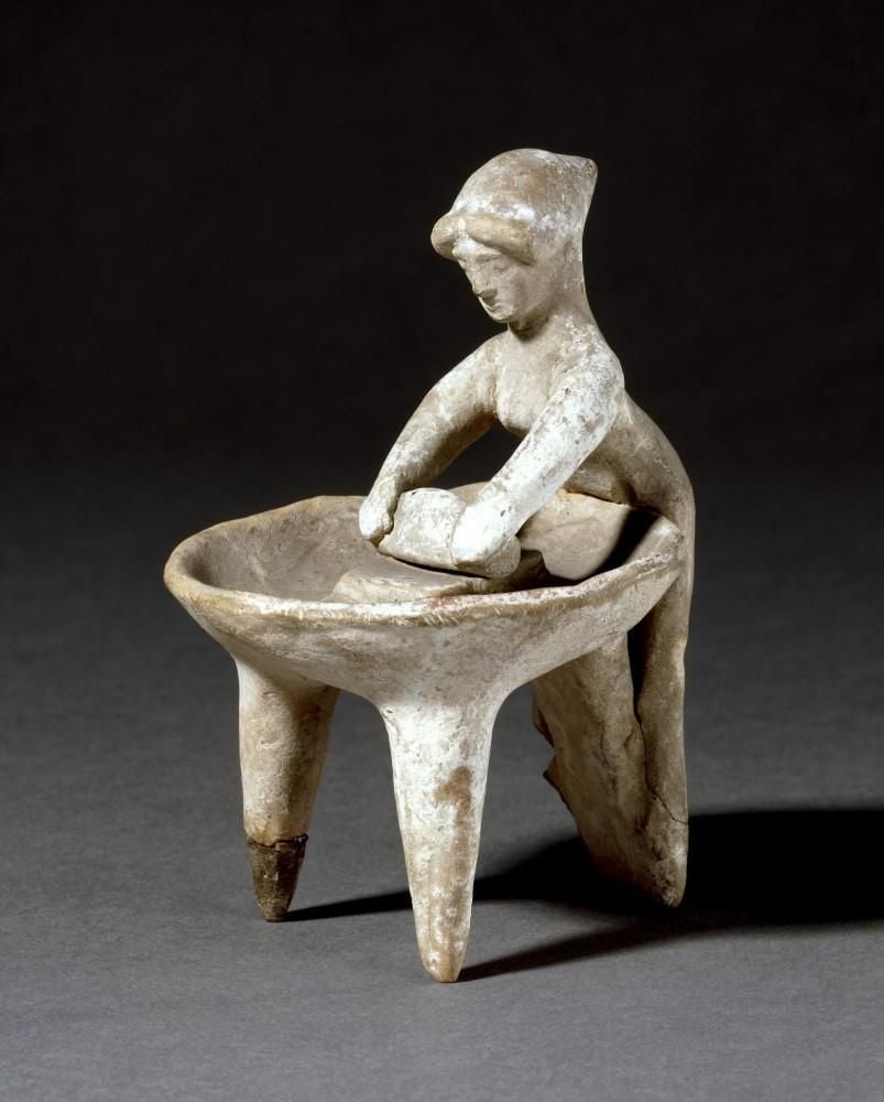 Terracotta model of a woman grinding wheat at a basin.