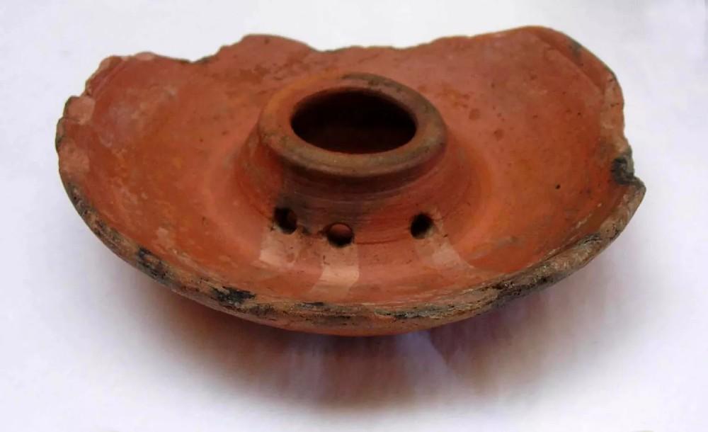 Wheel-made Classic Christian Fine Red Ware saucer lamp. The lamp dish is circular with a cylindrical oil reservoir rising from the centre, rim is tapered, portion is missing