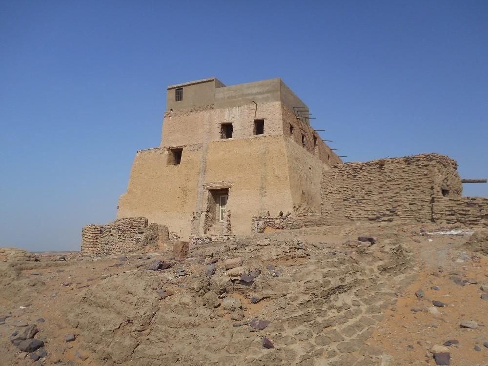 Two-storey brick building situated on a rocky hill