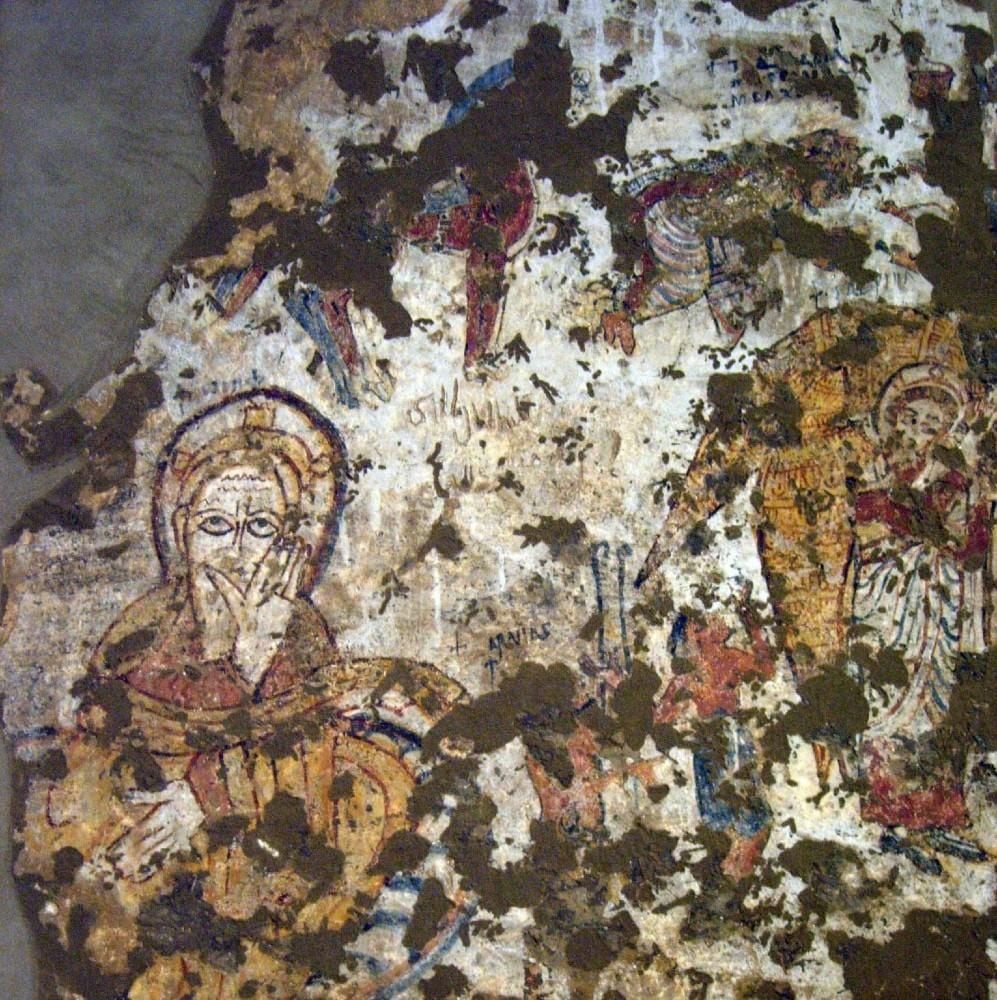 Portion of the wall painting of the Nativity with Joseph on the left and an angel on the right