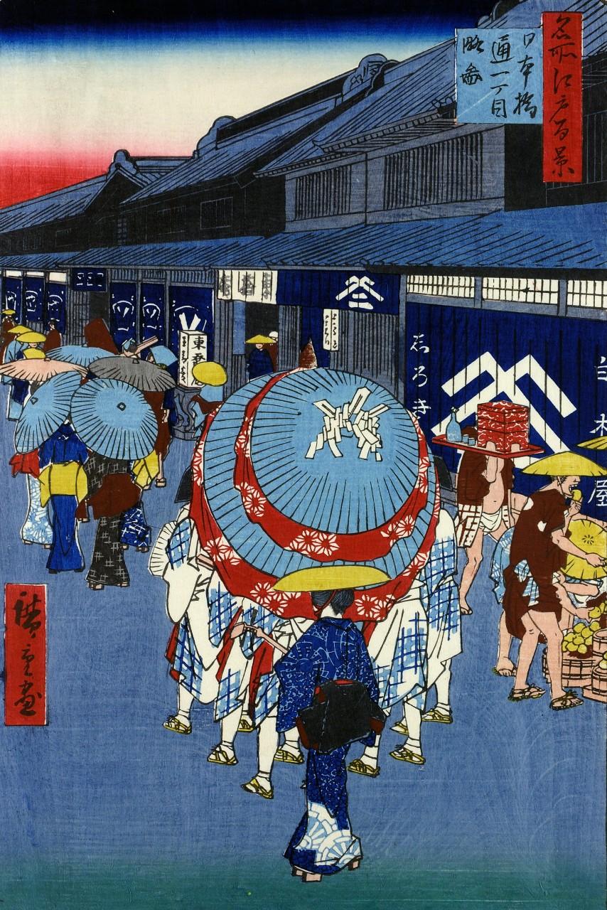 People sharing an umbrella on Nihon-bashi-dori, in busy street