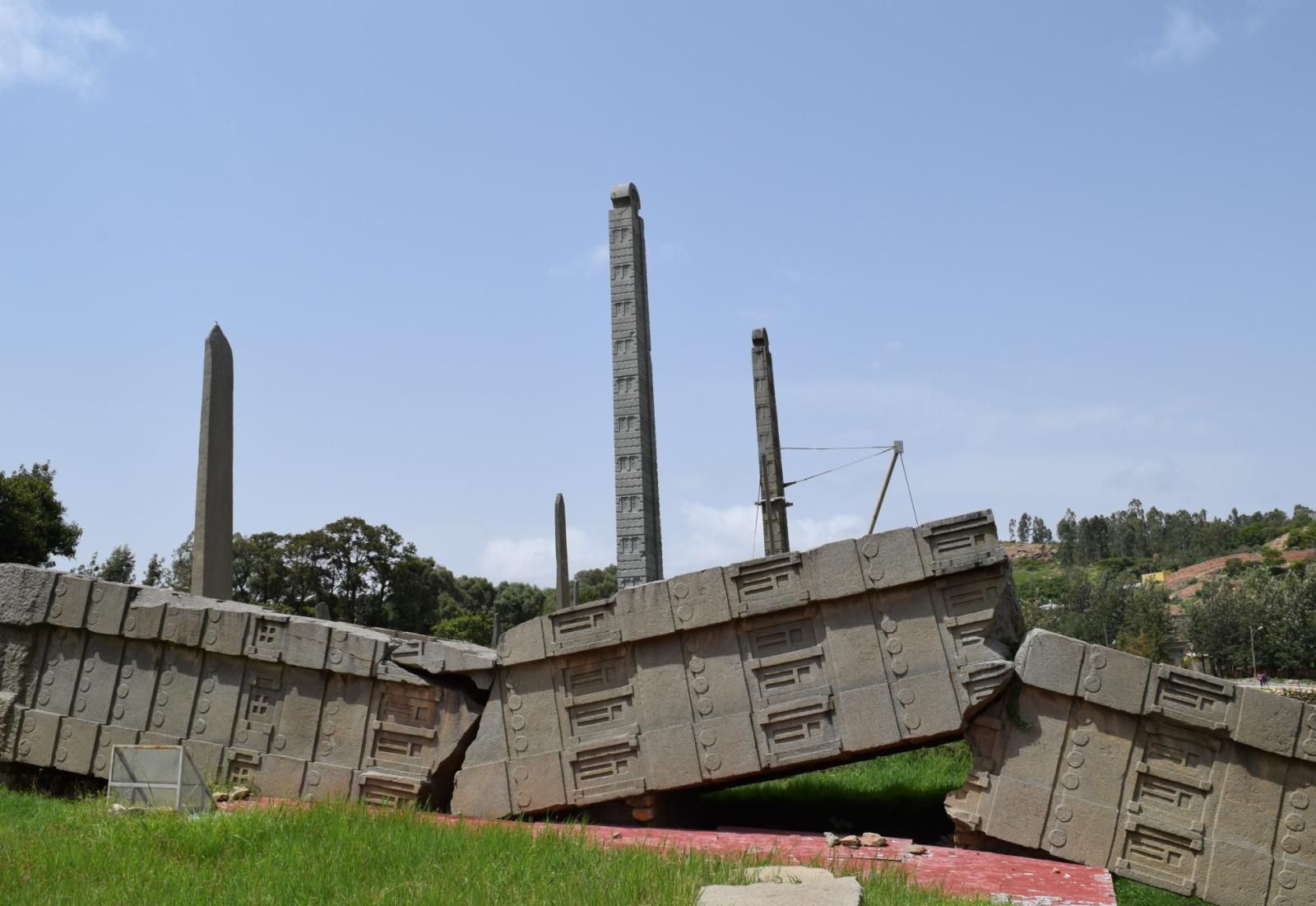 Modern photo showing a portion of the toppled stele with the smaller stelae in the background