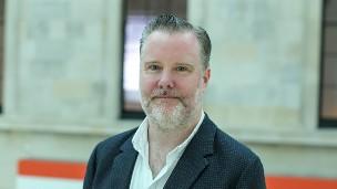 Headshot of Paul Stokes standing in the Great Court