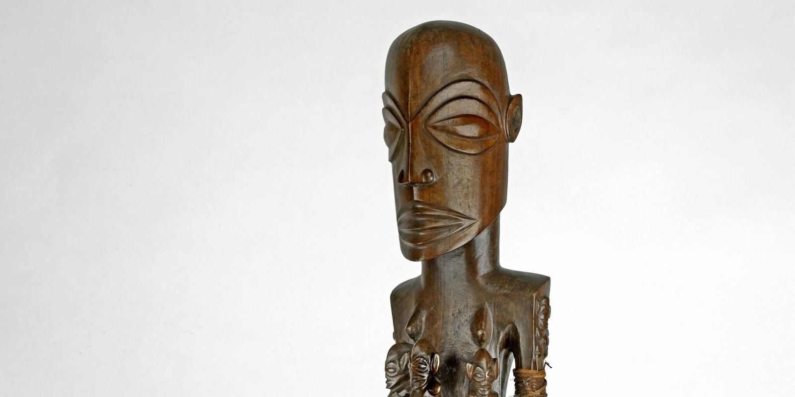 A wooden sculpture of a standing man.  