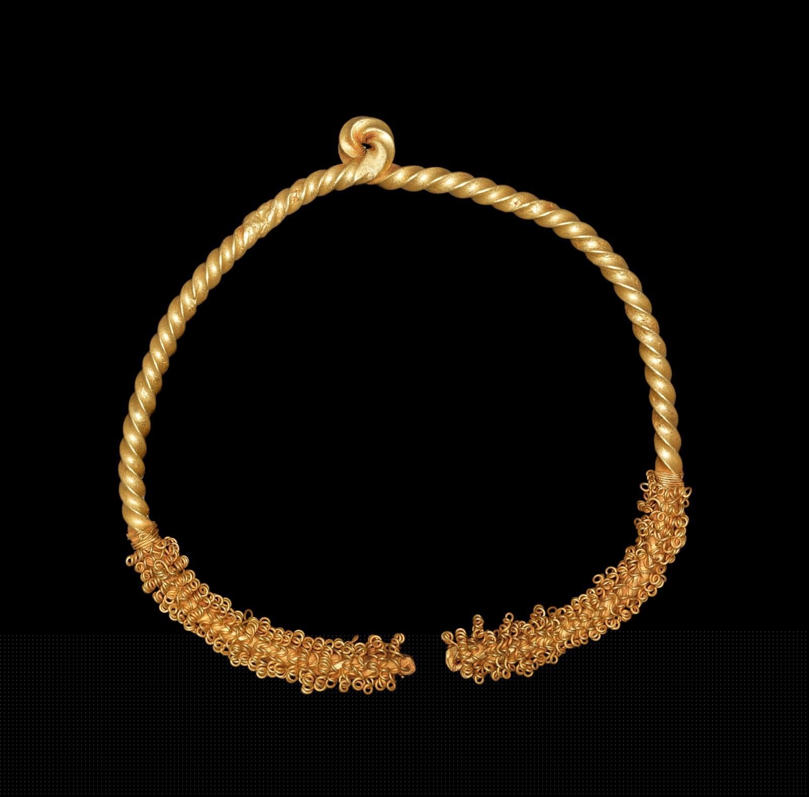 A neck torc made of twisted gold, with a loop at its centre and ends covered in fine gold spirals 