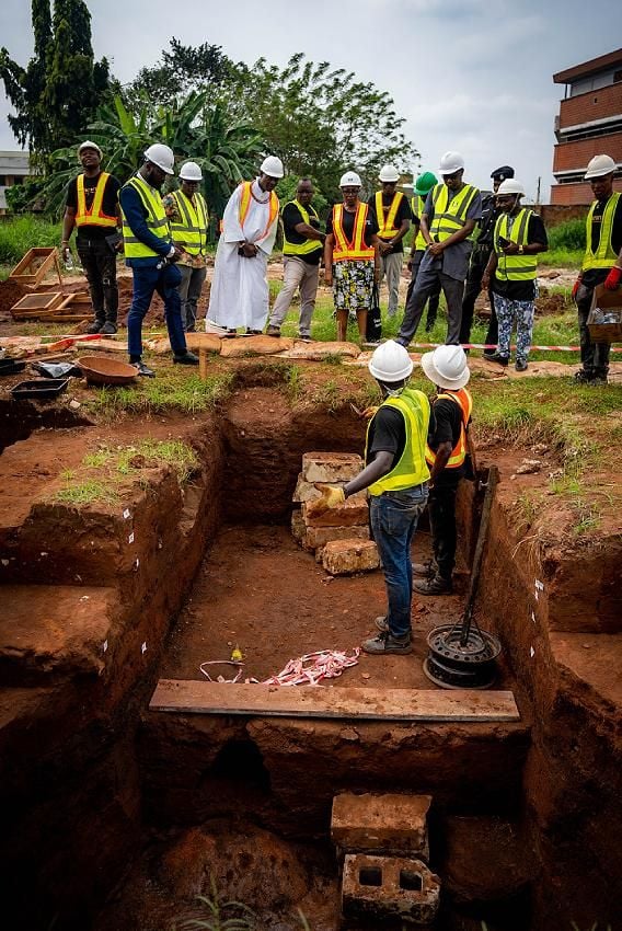 Large group at excavation site, in hard hats and high-visibility clothing