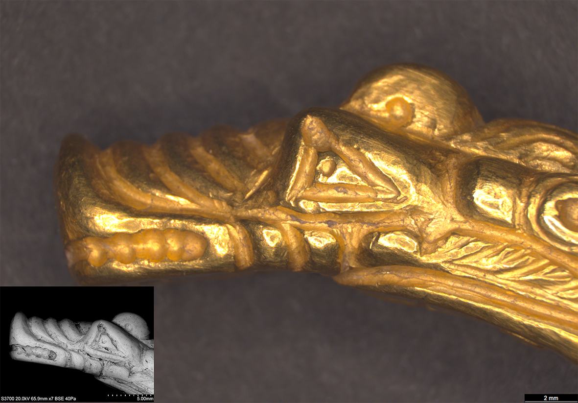 The gold head of a monster with long snout and large eyes