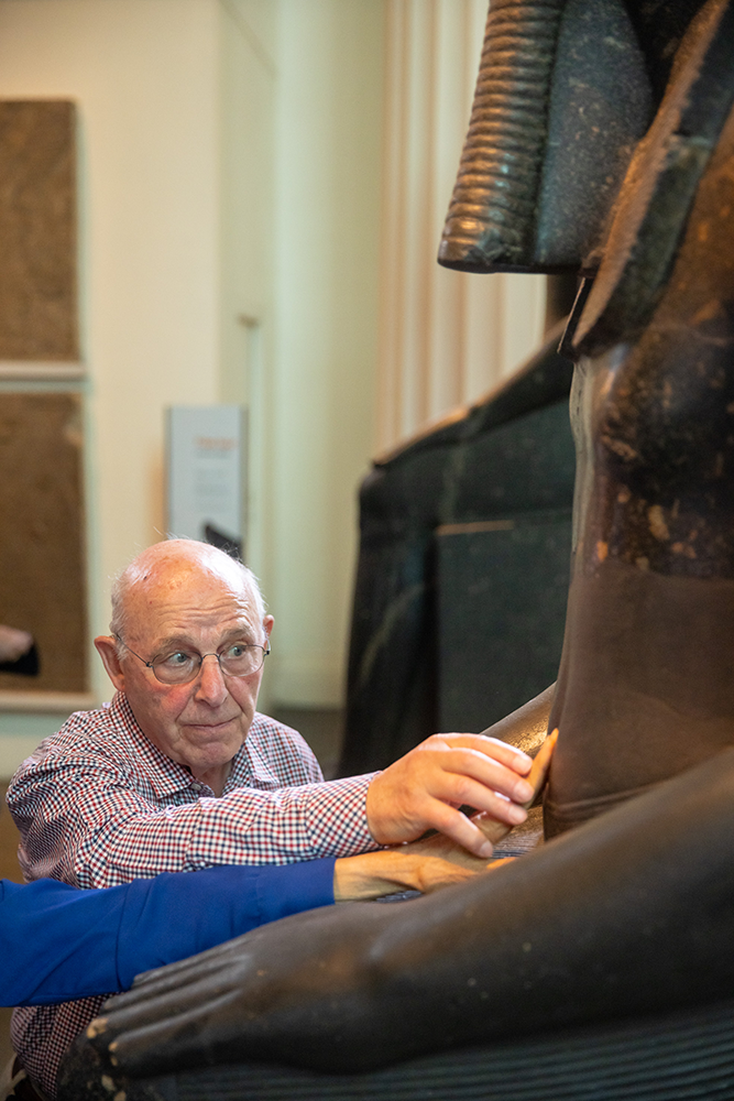 Tim guides a visitor to touch an ancient sculpture