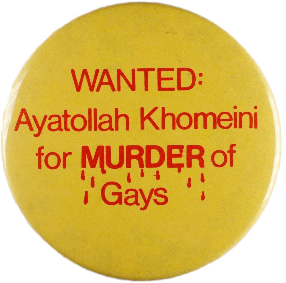 Yellow badge with red text that says: WANTED: Ayatollah Khomeini for MURDER of Gays. The word 'murder' has red drops of blood falling from it.