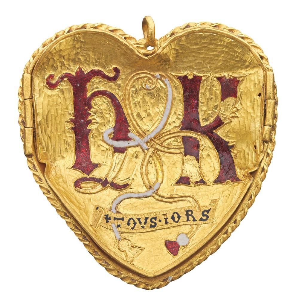 Gold pendant in the shape of a heart with the initials H and K in Lombardic script, and the words TOU IORS