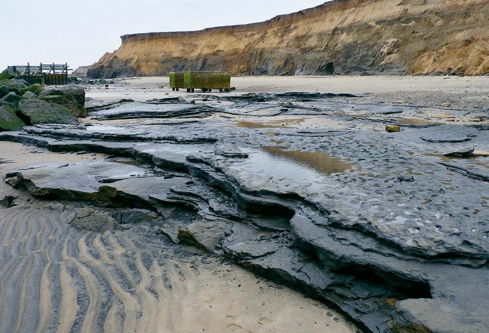 Happisburgh beach with stone terraces, sand and a sandy cliff