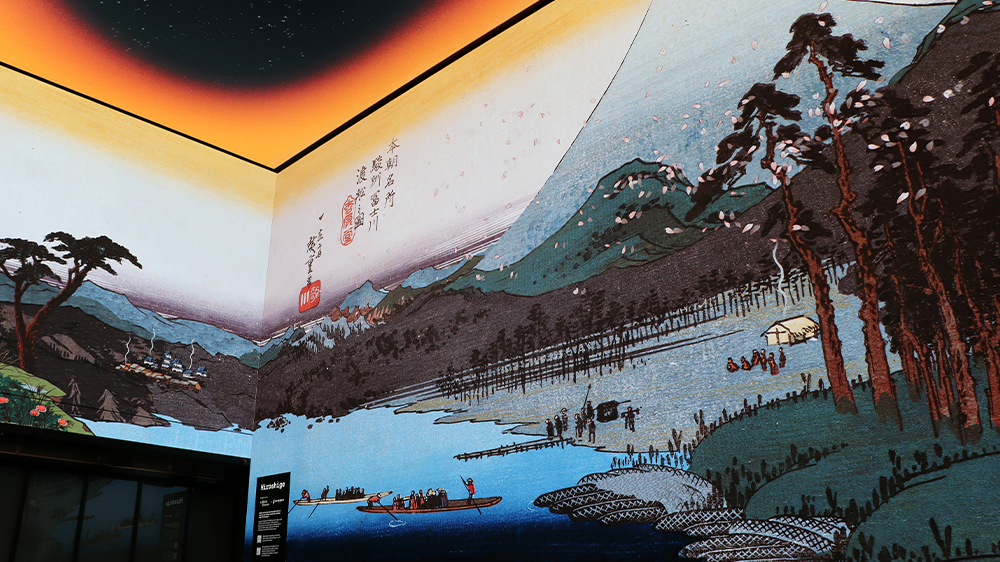 A colourful Japanese print of mount Fuji, waterways and trees appears across the walls of a 360 screen