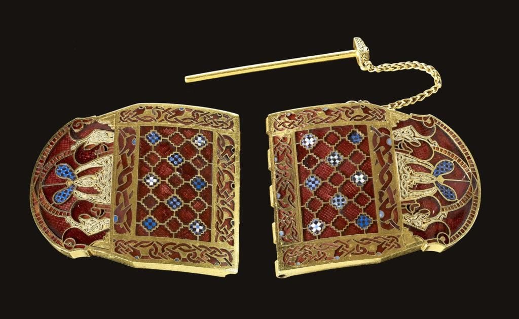 Gold shoulder clasp inlaid with garnet cloisonné and glass. A loop and chain is attached to the top of one side